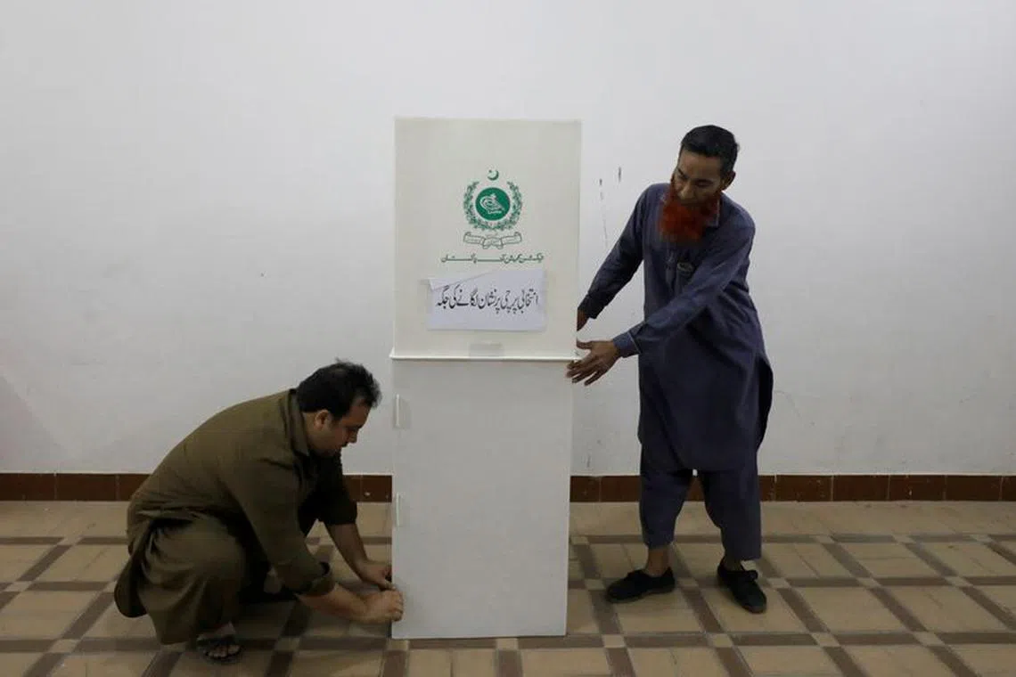 Polling staff prepare a polling booth at a school for the general election in Karachi, Pakistan February 7, 2024. REUTERS/Akhtar Soomro