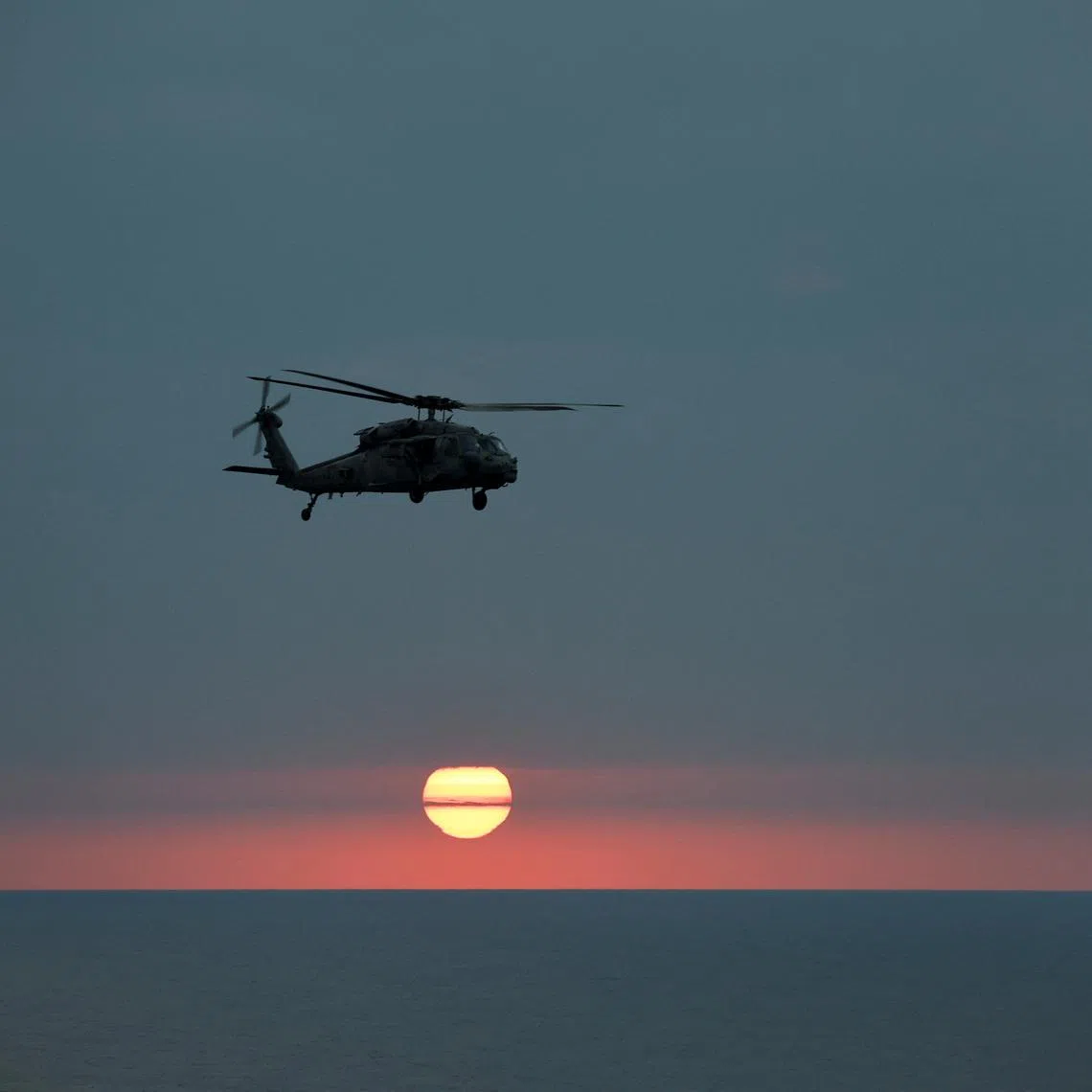 FILE PHOTO: An MH-60R Seahawk of The Swamp Foxes HSM-74 approaches the flight-deck of the USS Dwight D. Eisenhower (CVN 69) aircraft carrier during evening flight-operation in Southern Red Sea, Middle East, February 12, 2024. REUTERS/Hamad I Mohammed/File Photo