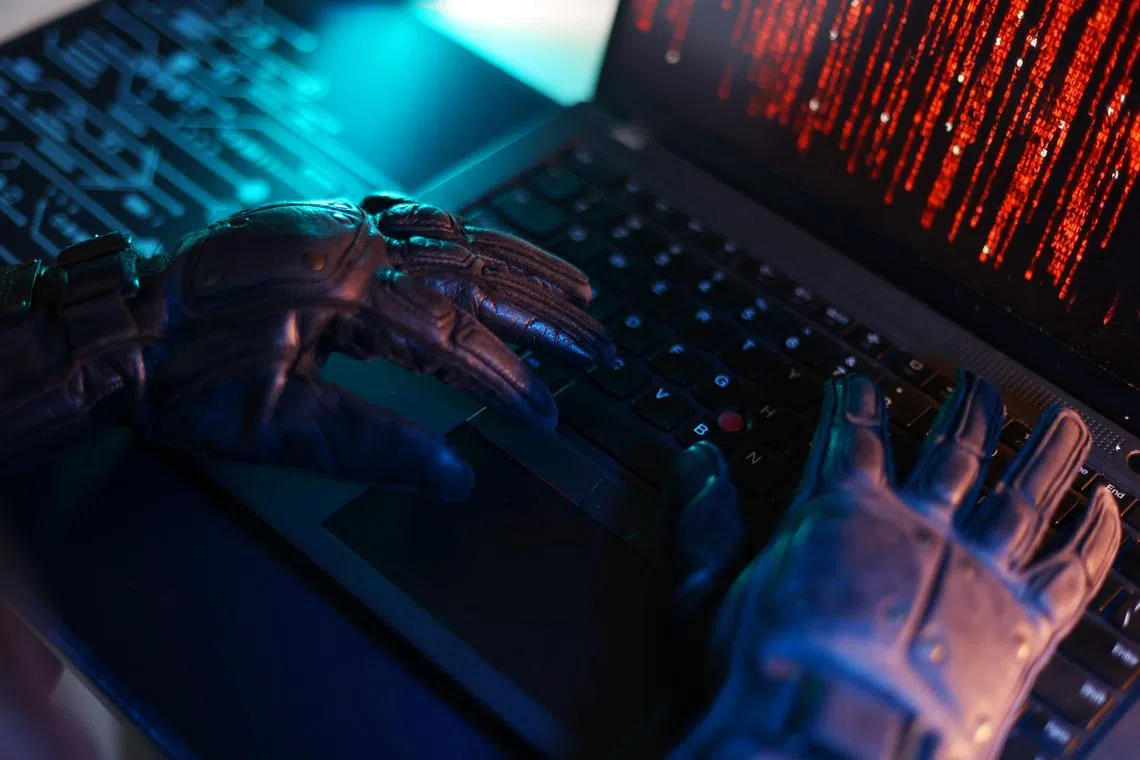 CMG20240725-HengYY03  / 王彦燕 / 犯罪示意图 ：Crime: Cyber crime concept. [SPH] Computer keyboard with hands in black gloves.Data theft stock photo.Hacker hand in glove.Thief stealing data from a laptop、scam、Online scam, scams, frauds, scammers, phishing, e-commerce scams 、phone scam、work scam 、Singapore dollars、滥用电脑、欺诈、意图、网络、科技犯罪、黑客、诈骗、恐袭