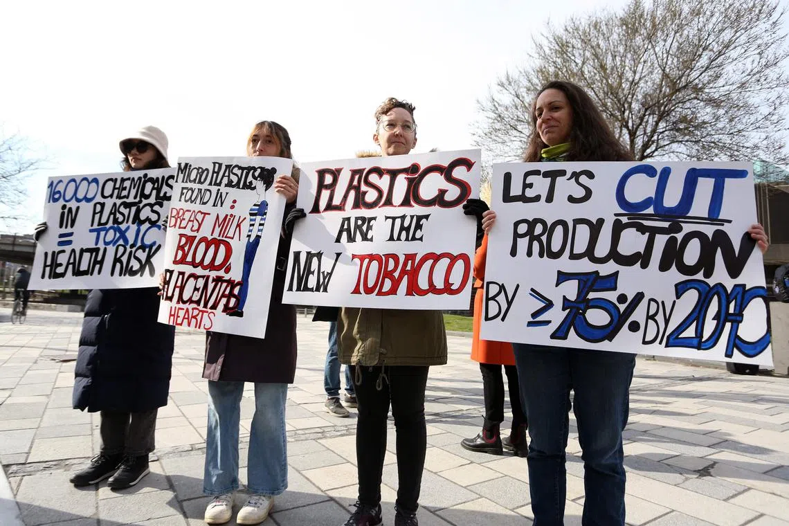 Members of Greenpeace holds up placards during the fourth session of the UN Intergovernmental Negotiating Committee on Plastic Pollution in Ottawa, Canada, on April 23, 2024. (Photo by Dave Chan / AFP)