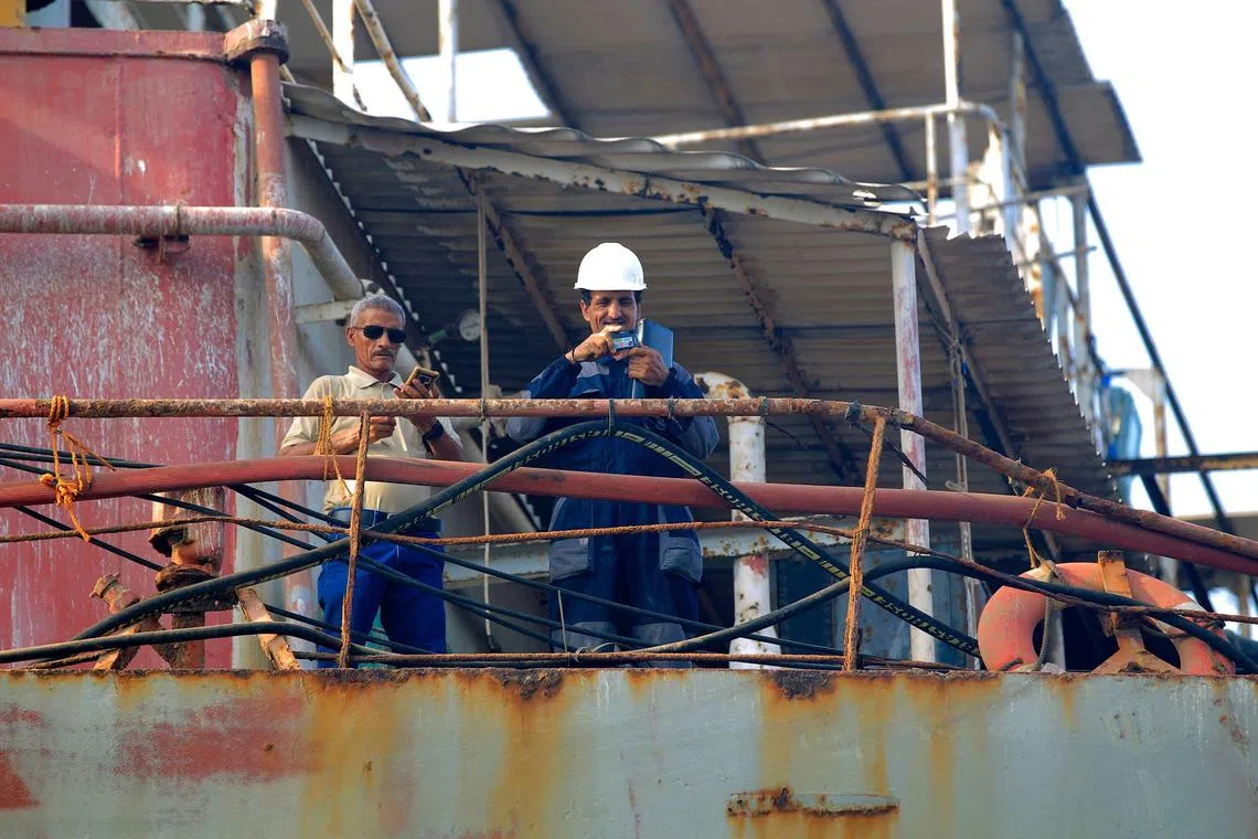 Workers stand on the deck of the beleaguered Yemen-flagged FSO Safer oil tanker in the Red Sea off the coast of Yemen's contested western province of Hodeida on July 15, 2023. The UN has secured insurance coverage allowing it to pump more than one million barrels of oil from the decaying tanker anchored off war-torn Yemen that poses the risk of a catastrophic spillage. (Photo by MOHAMMED HUWAIS / AFP)