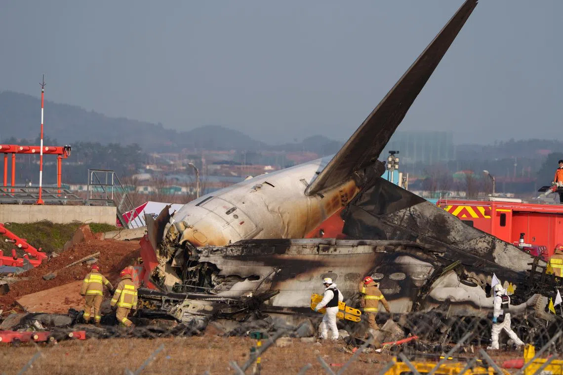 Firefighters and investigators at the scene of the Jeju Air passenger jet crash in Muan South Korea, Dec. 29, 2024. Except for two crew members rescued alive from the tail, all of the remaining 179 people onboard are confirmed dead, making the crash the worst aviation disaster for South Korean airline in nearly three decades, and the worst ever on South Korean soil. (Chang W. Lee/The New York Times)