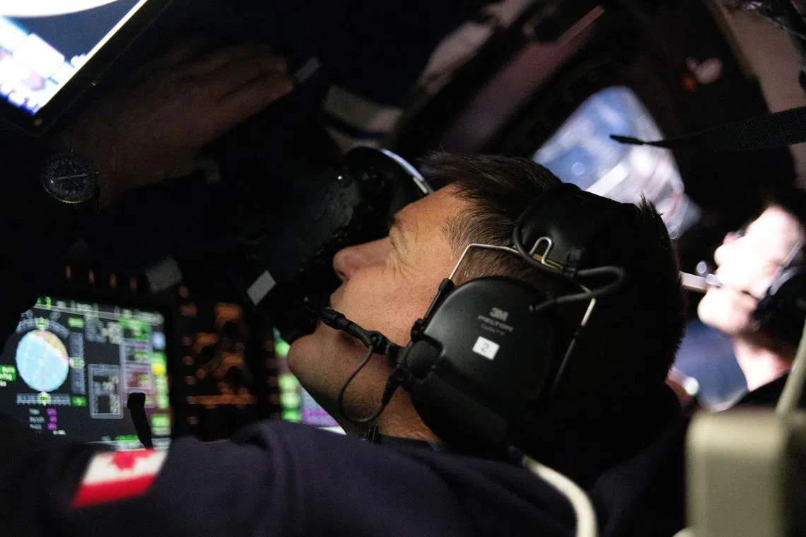 Canadian Space Agency (CSA) astronaut and Artemis II Mission Specialist Jeremy Hansen takes photographs through the Orion spacecraft's window during the Artemis II crew’s flyby of the Moon April 6, 2026.  Picture released April 7, 2026.      NASA/Handout via REUTERS