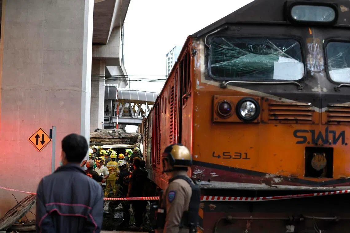 Thai rescue workers search for victims following a collision between a freight train and a bus at the Airport Rail Link's Makkasan station in Bangkok, Thailand, on May 16.