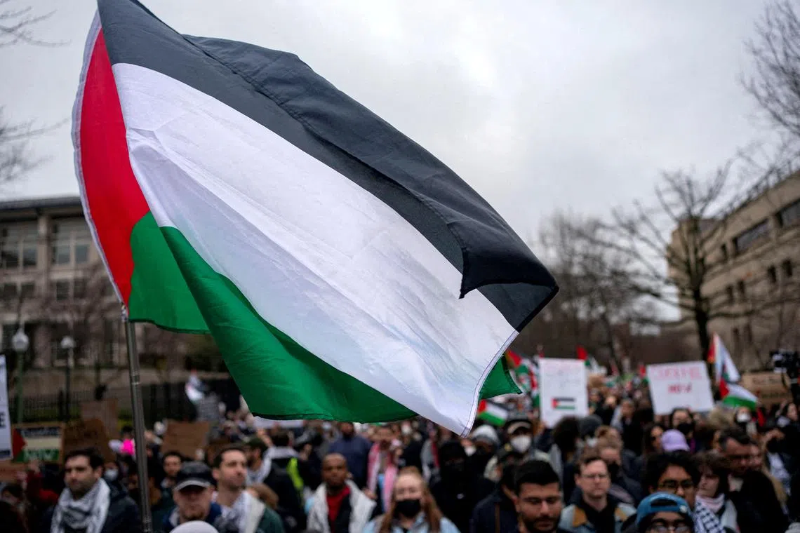 FILE PHOTO: A Palestinian flag flies over a group of pro-Palestinian demonstrators as they march outside the Israeli embassy to call for a ceasefire in Gaza, amid the ongoing conflict between Israel and the Palestinian Islamist group Hamas, during a protest in Washington, U.S., March 2, 2024. REUTERS/Bonnie Cash/File Photo