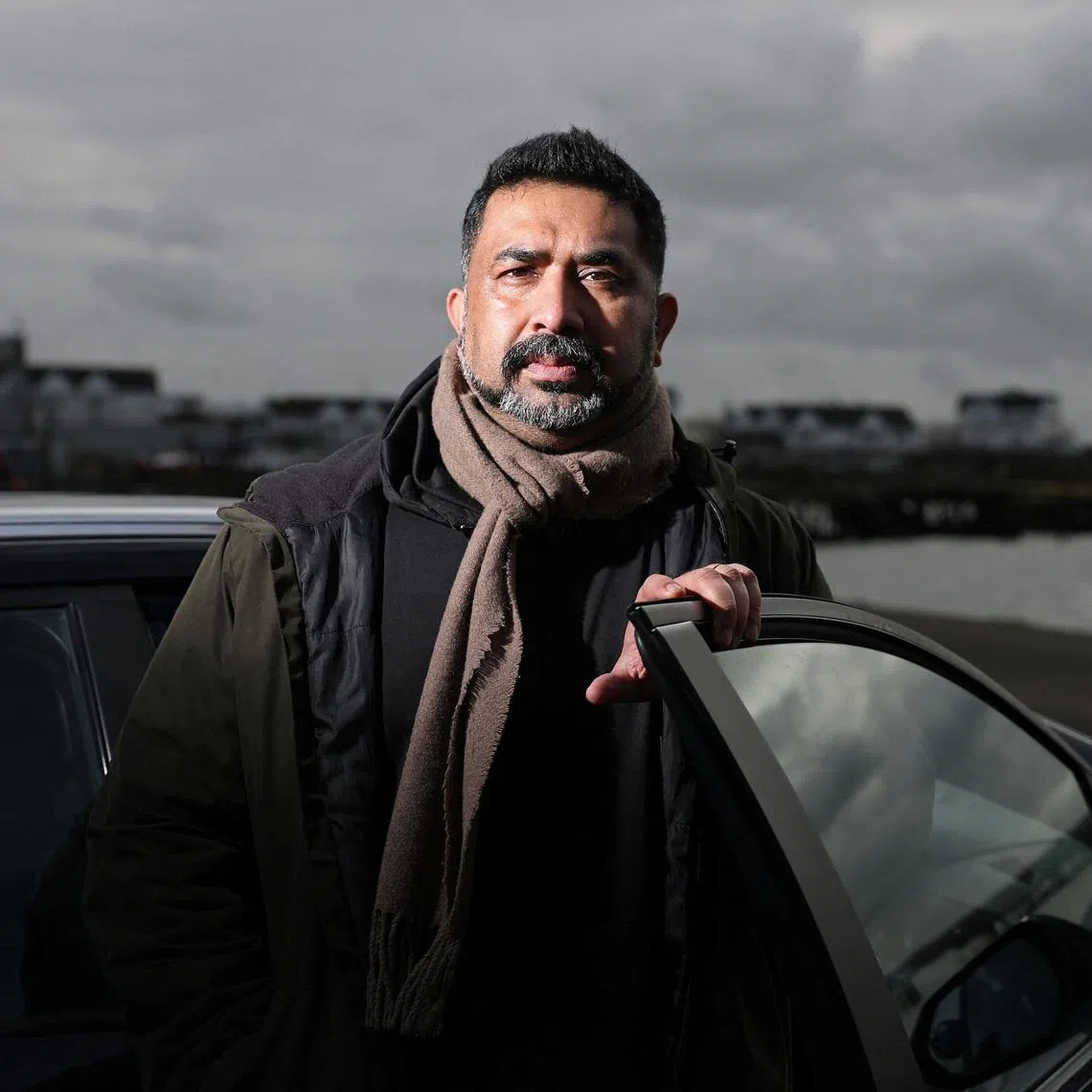 Private hire driver Ali Haydor poses beside his car during an interview with Reuters in Southampton, Britain, February 23, 2026. REUTERS/Toby Melville