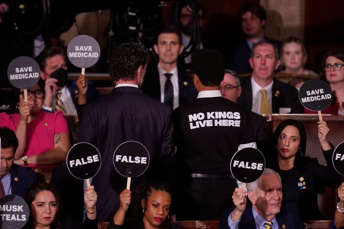 House Democrats hold signs in protest during a joint session of Congress in the House Chamber of the US Capitol on March 4.