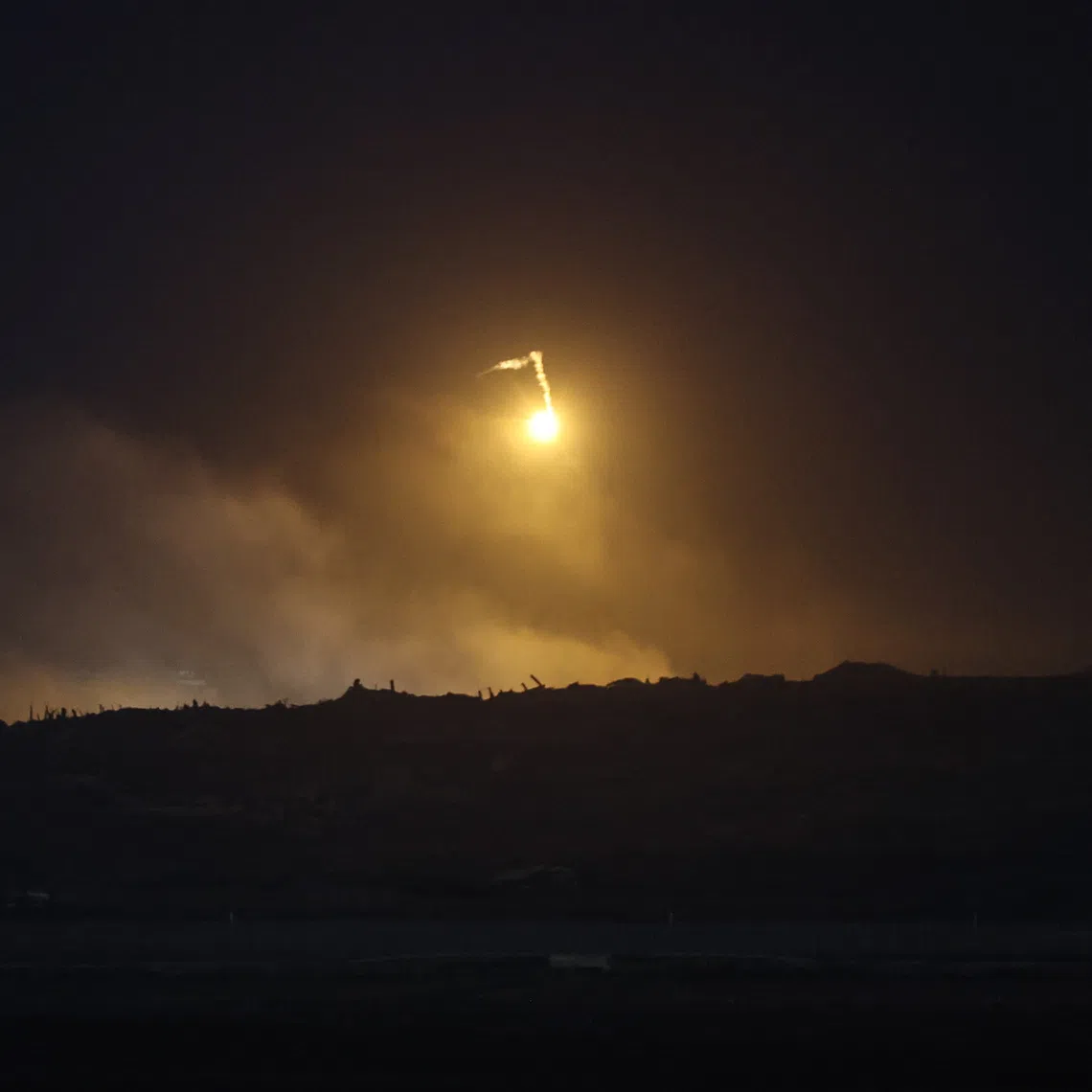 A flare fired by the Israeli army over the northern part of Gaza is seen from Kfar Aza, southern Israel, on Oct 29.