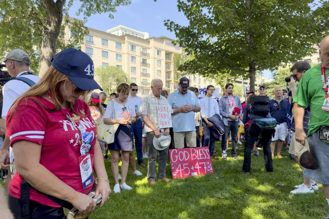 Attendees pray during a vigil at Zeidler Park in Milwaukee, on July 14.