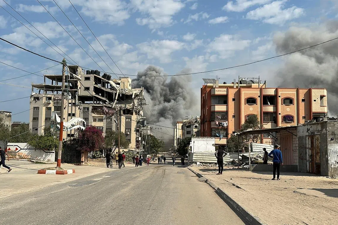 Palestinians watch as smoke rises following Israeli strikes, amid the ongoing conflict between Israel and Hamas, in Nuseirat in the central Gaza Strip, November 1, 2024. REUTERS/Khamis Said