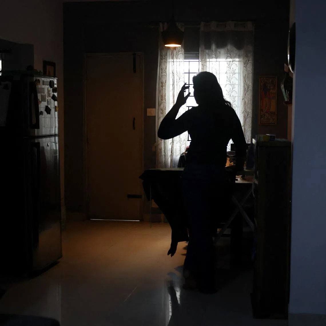 Ananya, 24, a Bengaluru-based business development manager, irons her clothes before leaving for the office in Bengaluru, India, June 10, 2026. REUTERS/Priyanshu Singh
