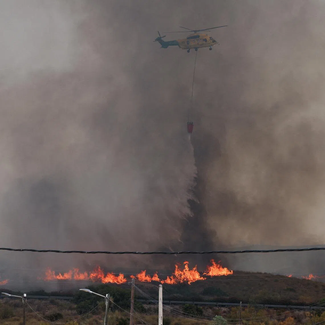 A firefighting helicopter dumps water amid deadly wildfires affecting Almeria province in Spain that started on July 9.