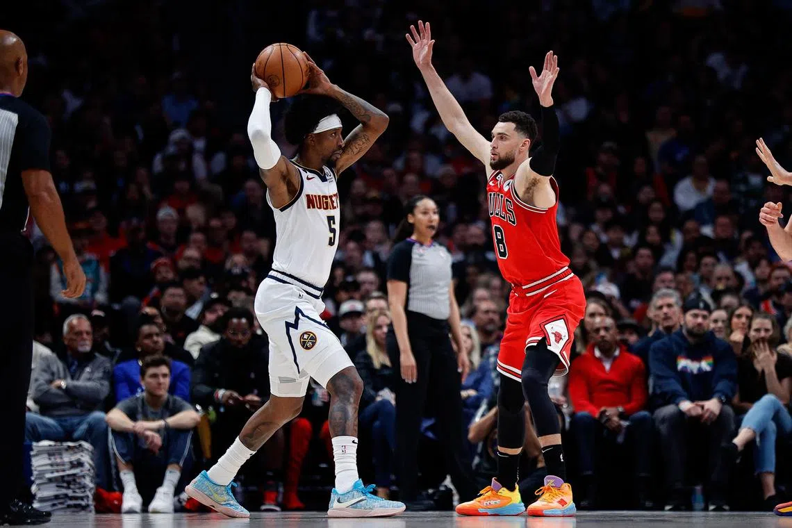 Denver Nuggets guard Kentavious Caldwell-Pope controls the ball as Chicago Bulls guard Zach LaVine defends in the second quarter at Ball Arena.
