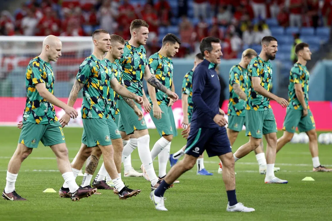 Australia's high-performance coordinator Andrew Clark (in blue) leading the Socceroos in their pre-game warm-against Denmark on Nov 30. 