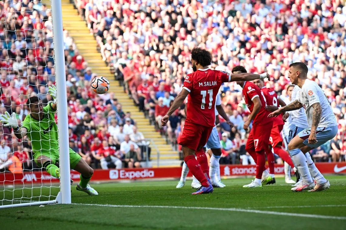 Liverpool's Egyptian striker Mohamed Salah scoring his team third goal during their English Premier League 3-0 win over Aston Villa at Anfield on Sunday.