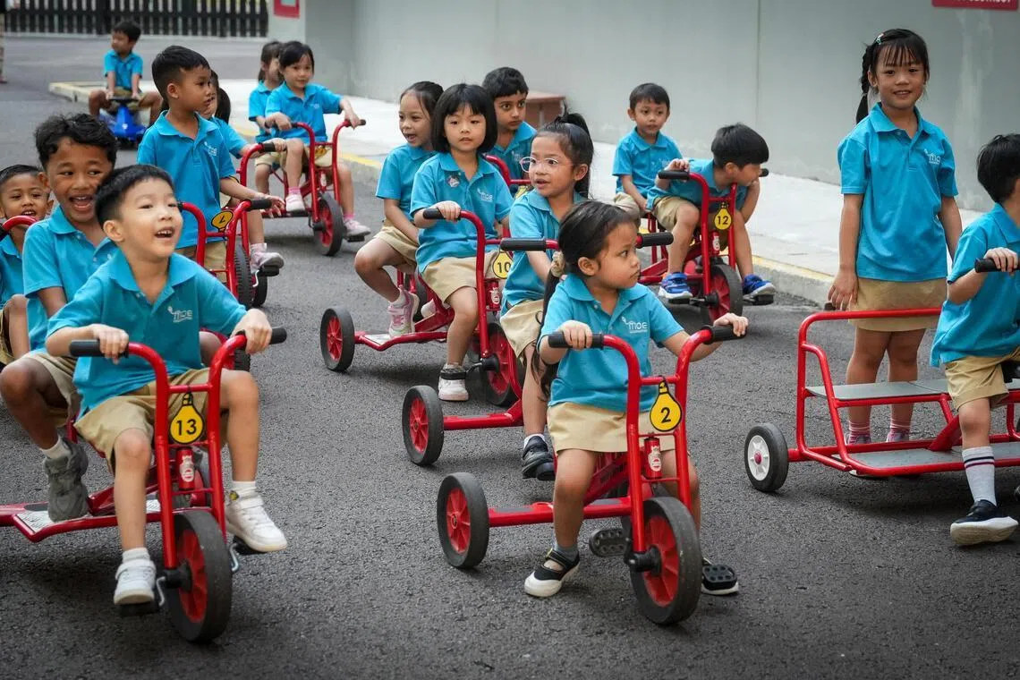 绿洲小学内的教育部幼儿园学生骑着儿童脚踏车游玩。