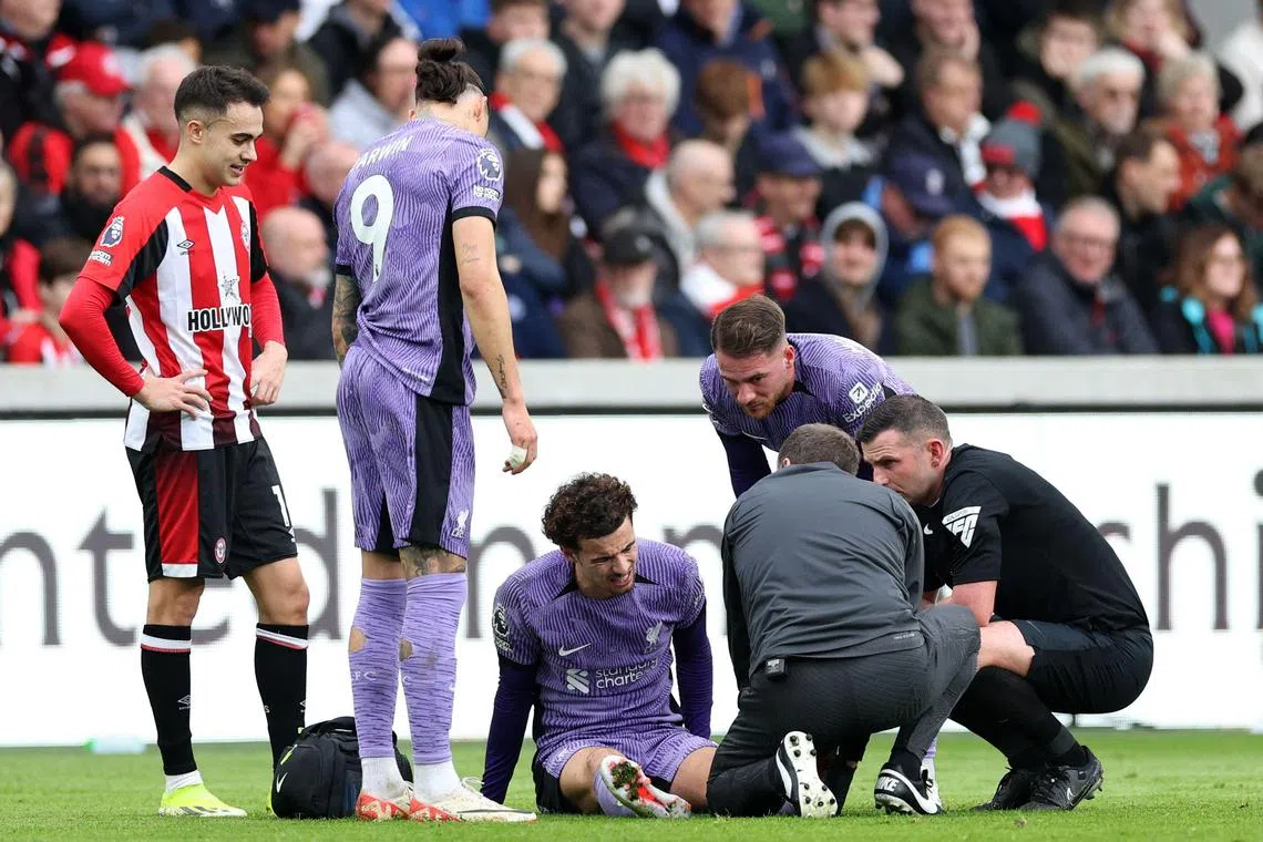 Liverpool's English midfielder Curtis Jones is treated by medical staff during the match against Brentford.