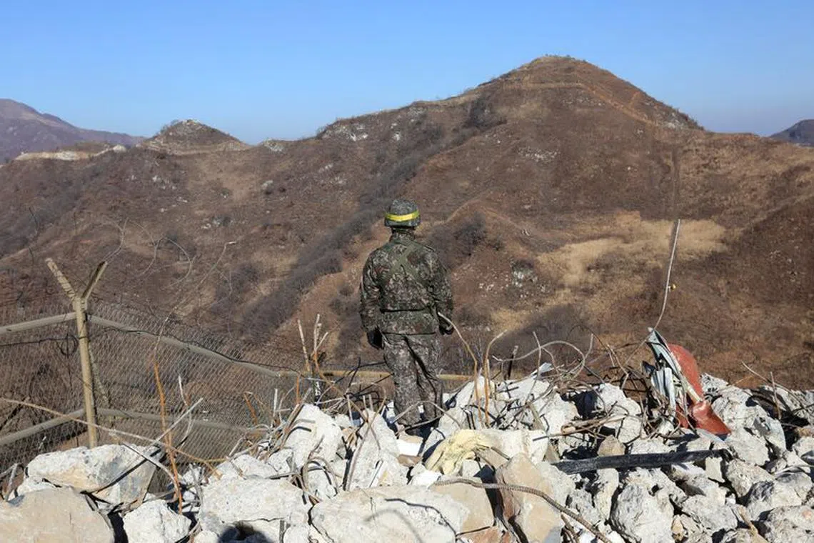 FILE PHOTO: A South Korean army soldier stands guard at the South's dismantled guard post inside the Demilitarized Zone (DMZ) in the central section of the inter-Korean border in Cheorwon.