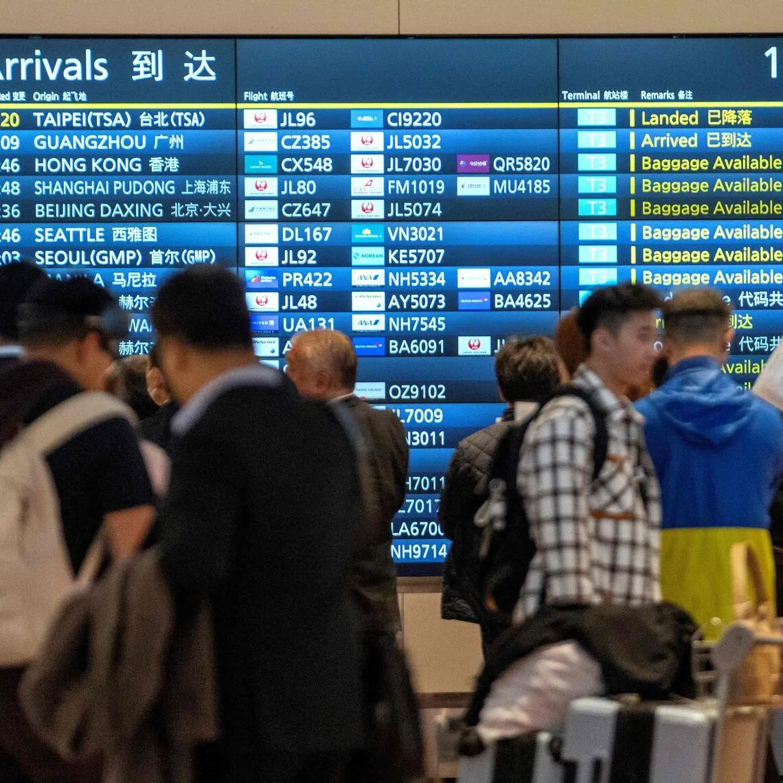 A notice board announces international arrivals at Tokyo's Haneda airport.
