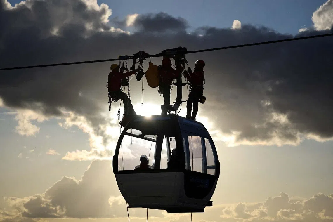 French firefighters attend an evacuation exercise for a passenger suffering from illness on the C1 urban cable car by the Ile-de-France Mobilites public transport agency which will connect the cities of Villeneuve-Saint-Georges, Limeil-Brevannes, Valenton and Creteil, in Limeil-Brevannes near Paris, France, November 20, 2025. REUTERS/Sarah Meyssonnier TPX IMAGES OF THE DAY