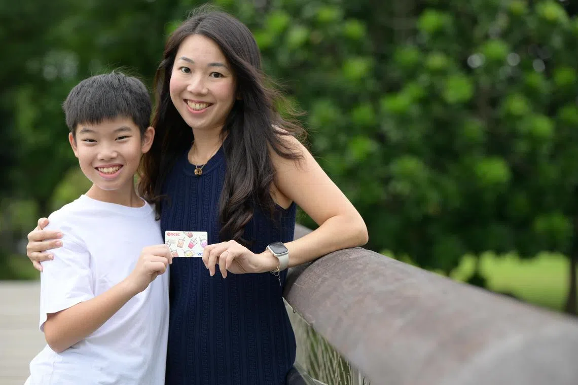 Ms Jeaneve Wee, 44, and her son, Jayden Hor, 11, pose with his OCBC MyOwn debit card, which cater to youth aged seven to 15.