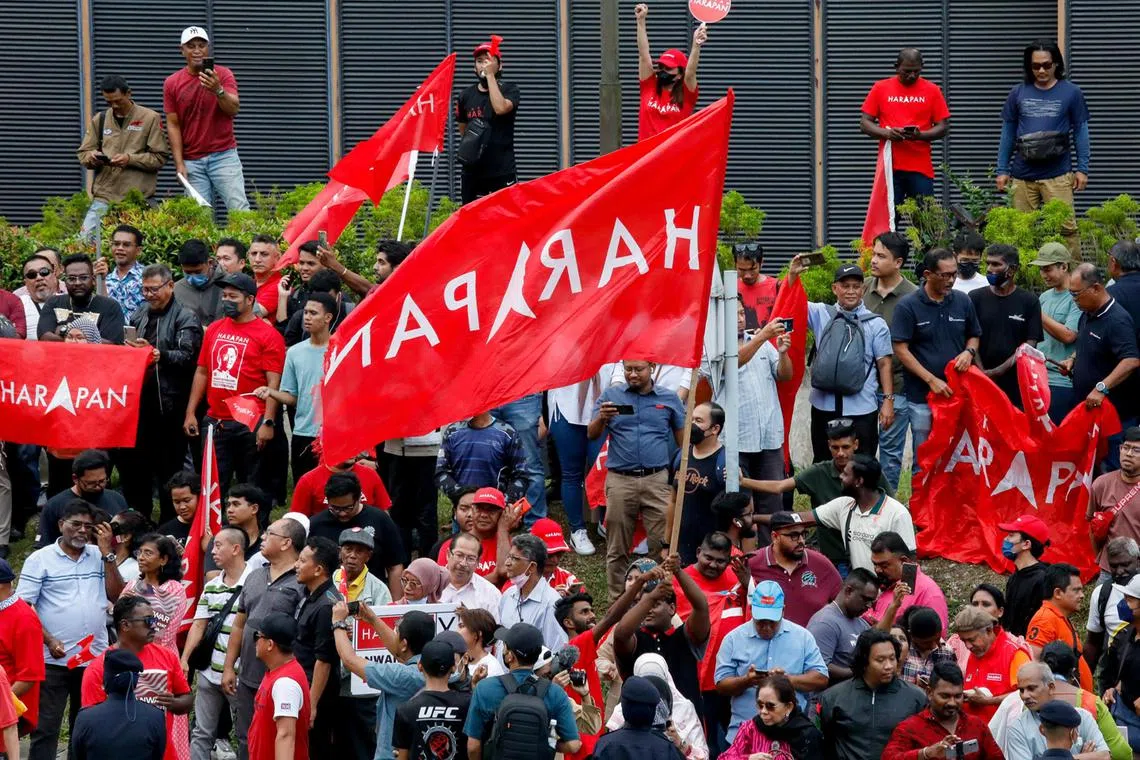 Supporters of Malaysia's newly appointed Prime Minister Anwar Ibrahim hold his Pakatan Harapan (PH) party flags as they celebrate outside the Istana Negara (National Palace) in Kuala Lumpur, Malaysia, Nov 24, 2022. 