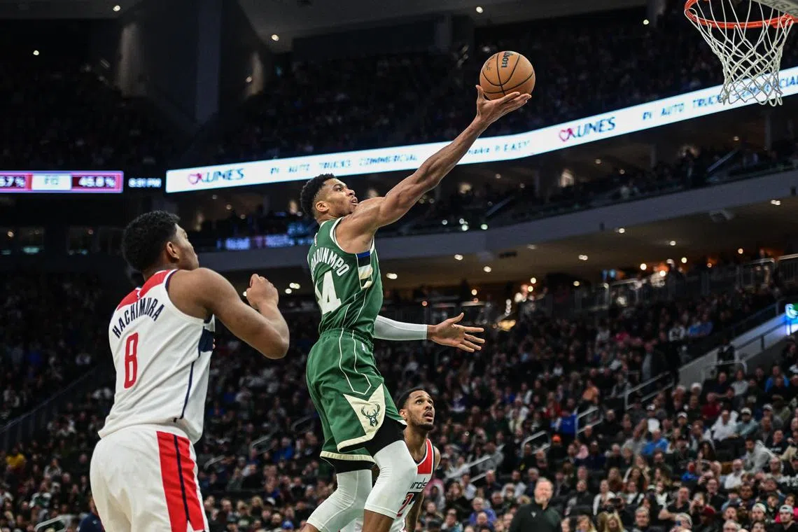 Jan 3, 2023; Milwaukee, Wisconsin, USA;  Milwaukee Bucks forward Giannis Antetokounmpo (34) takes a shot against Washington Wizards forward Rui Hachimura (8) in the third quarter at Fiserv Forum. Mandatory Credit: Benny Sieu-USA TODAY Sports