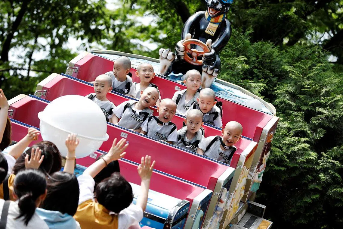 Boys who are experiencing the lives of Buddhist monks by staying in a temple for three weeks as novice monks, enjoy a ride at Everland amusement park in Yongin, South Korea, May 17.
