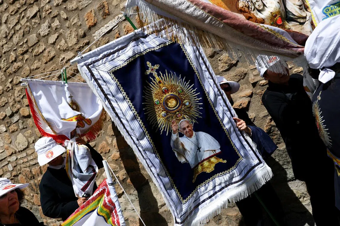 Faithful leave with their banners outside St. Peter's Square, following the funeral Mass of Pope Francis, in Rome, Italy, April 26, 2025. REUTERS/Kai Pfaffenbach