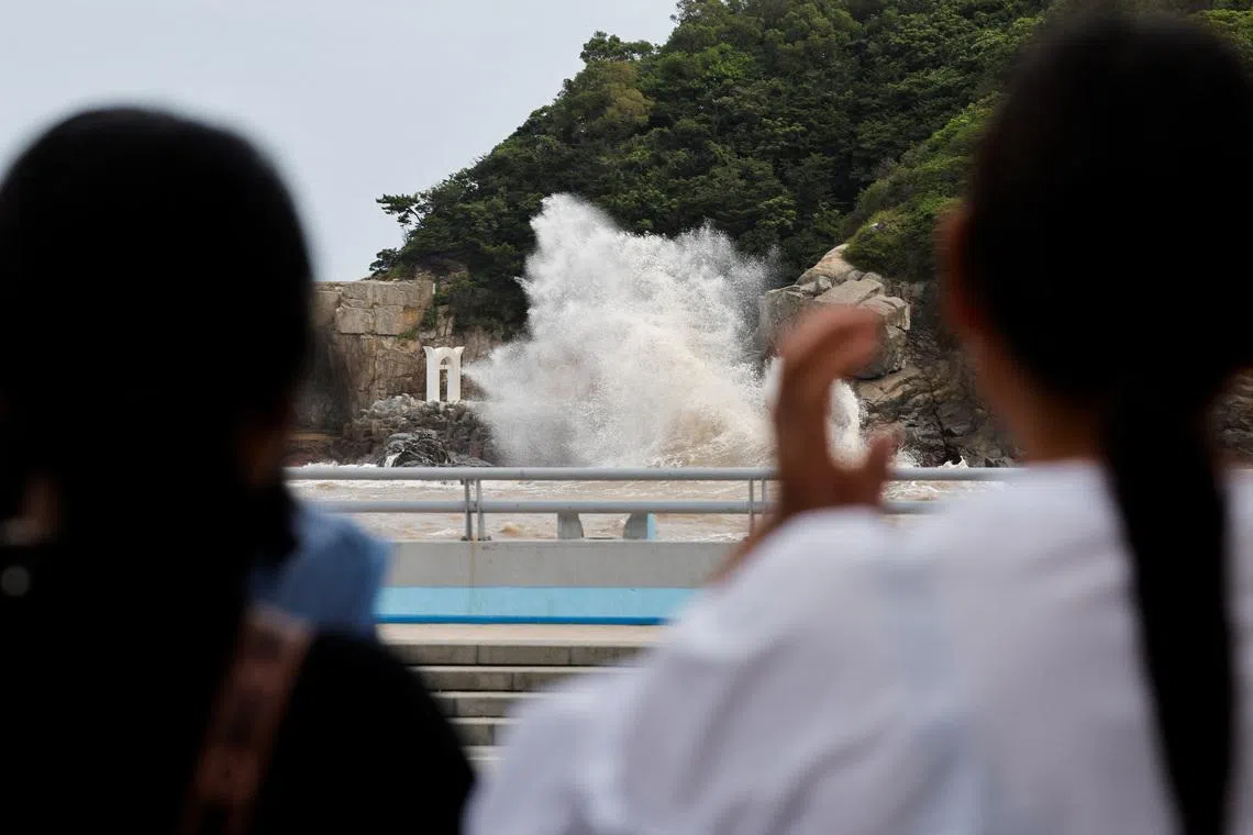 People watch waves crash against the shore as Typhoon Bavi approaches, in Wenzhou, Zhejiang province, China July 10, 2026. REUTERS/Go Nakamura
