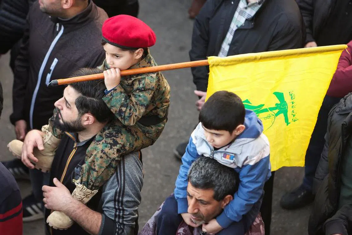 A child holds a Hezbollah flag during the funeral of Hezbollah member Mohammed Hassan Jaafar Makke, who was killed in southern Lebanon amid tension between Israel and Hezbollah, in Beirut's southern suburbs, Lebanon, December 20, 2023. REUTERS/Aziz Taher