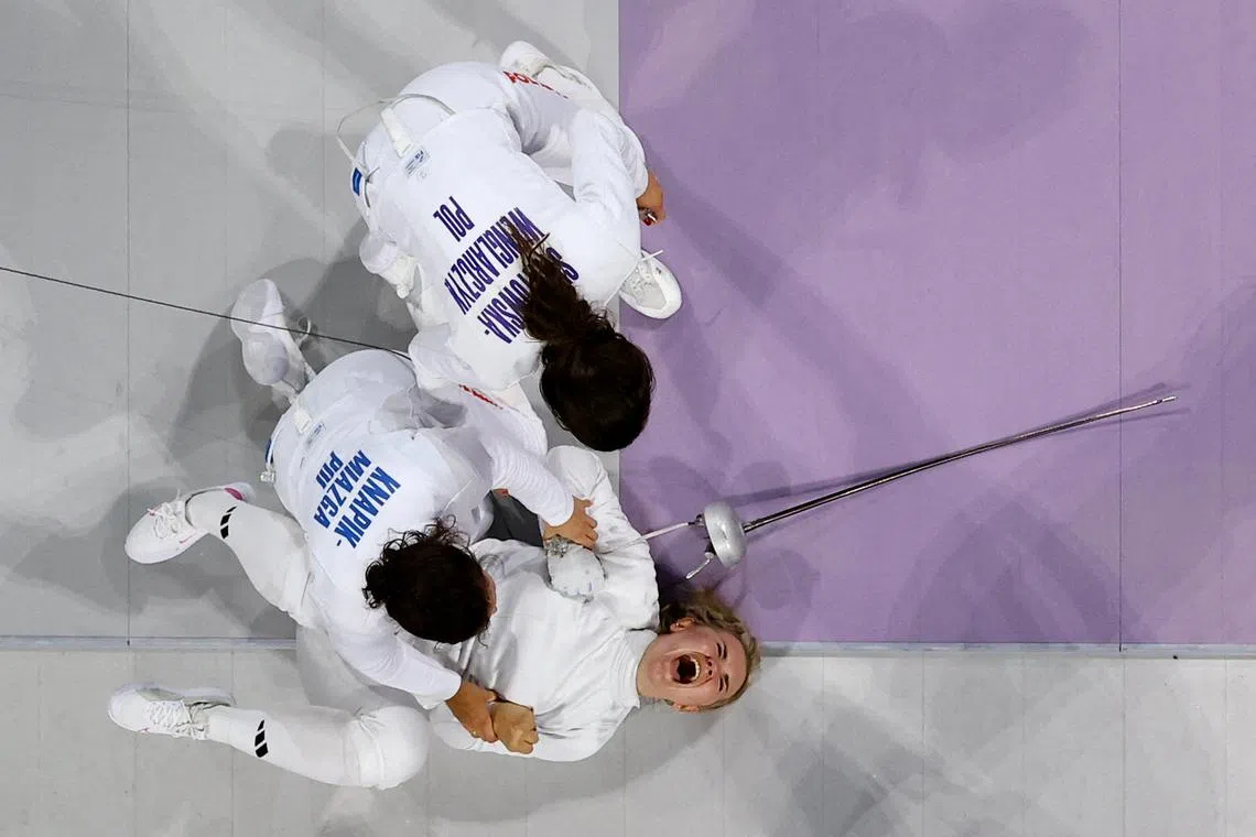 Aleksandra Jarecka and Martyna Swatowska-Wenglarczyk of Poland celebrating with teammates, after winning the bronze medal during women's epee team bronze medal match, at the Paris 2024 Olympics, held at the Grand Palais, Paris, France, on July 30, 2024.