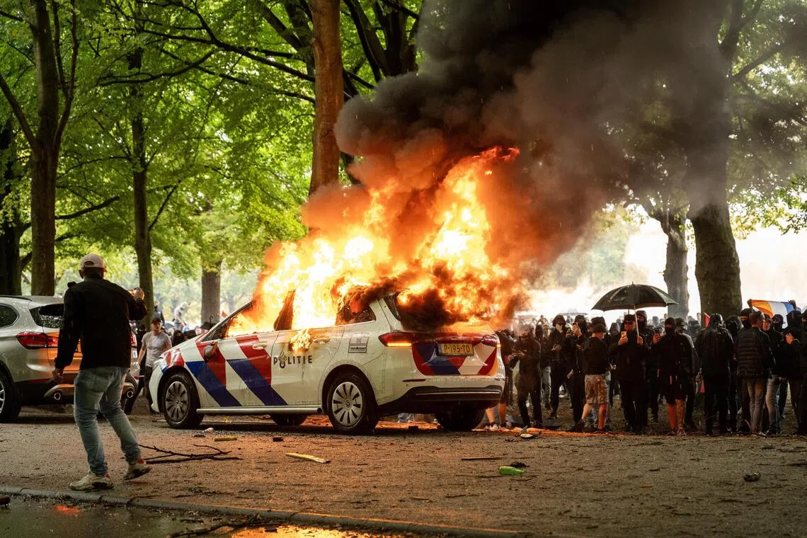 A police car set on fire during a protest in the Hague, the Netherlands, on Sept 20.