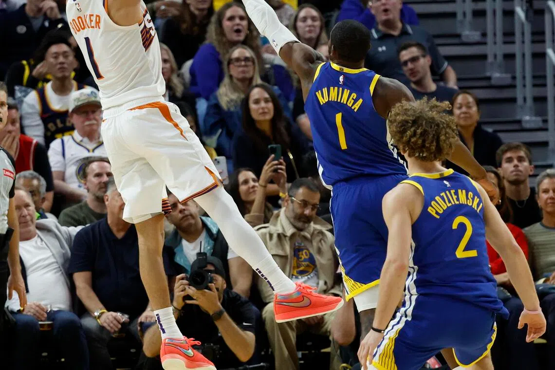 Phoenix Suns guard Devin Booker shoots a two-point basket over Golden State Warriors forward Jonathan Kuminga during the second half.