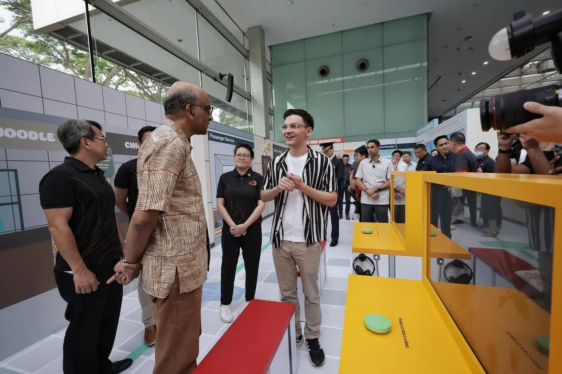 President Tharman Shanmugaratnam interacting with Mr William Koh, 19-year-old national serviceman and caregiver to his mother who has dementia, at the launch of an interactive exhibition, as part of this year's national #DementiaFriendlySG campaign, at National Museum of Singapore on Jan 6, 2024. ST PHOTO: KEVIN LIM jtdementia06