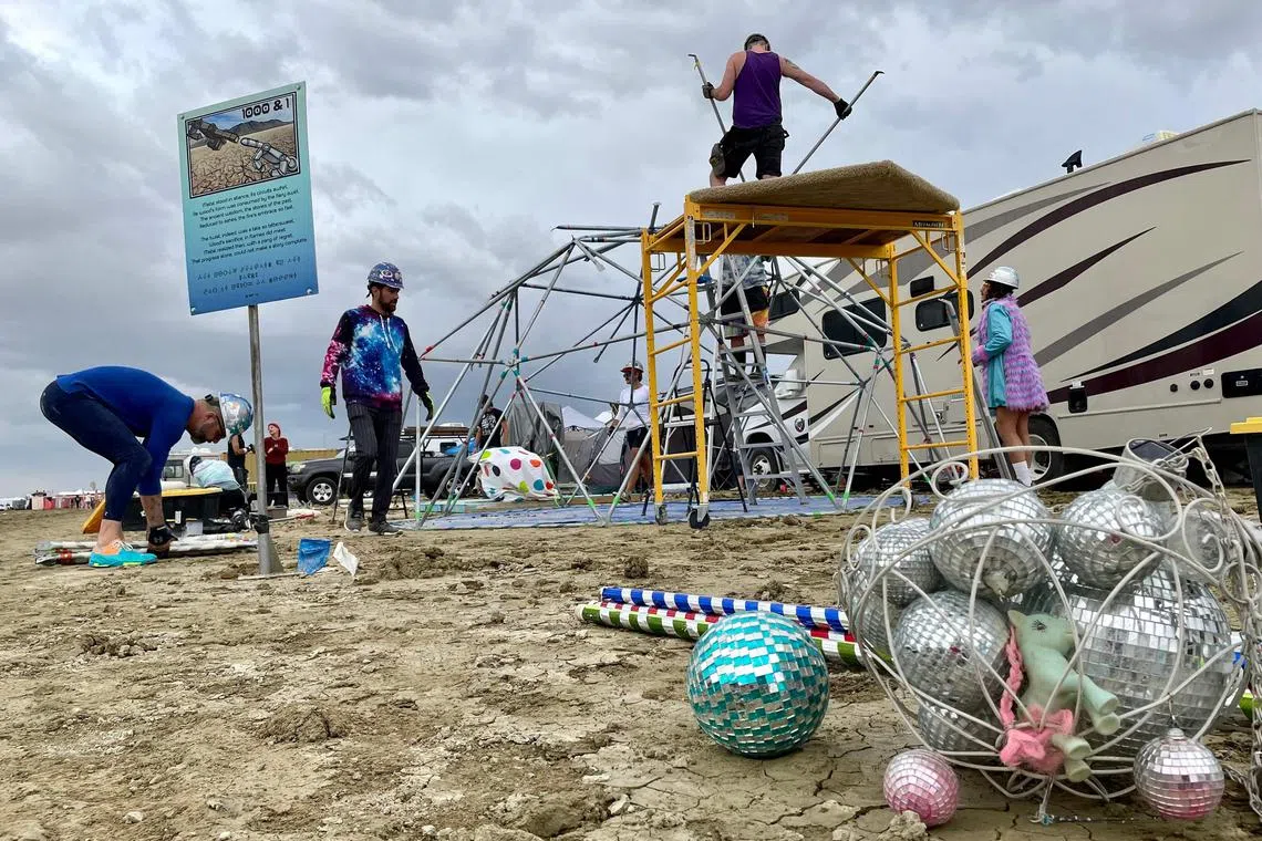 Attendees known as "burners" strike down their Unicorner camp before new rainfalls in a muddy desert plain on Sept 3.