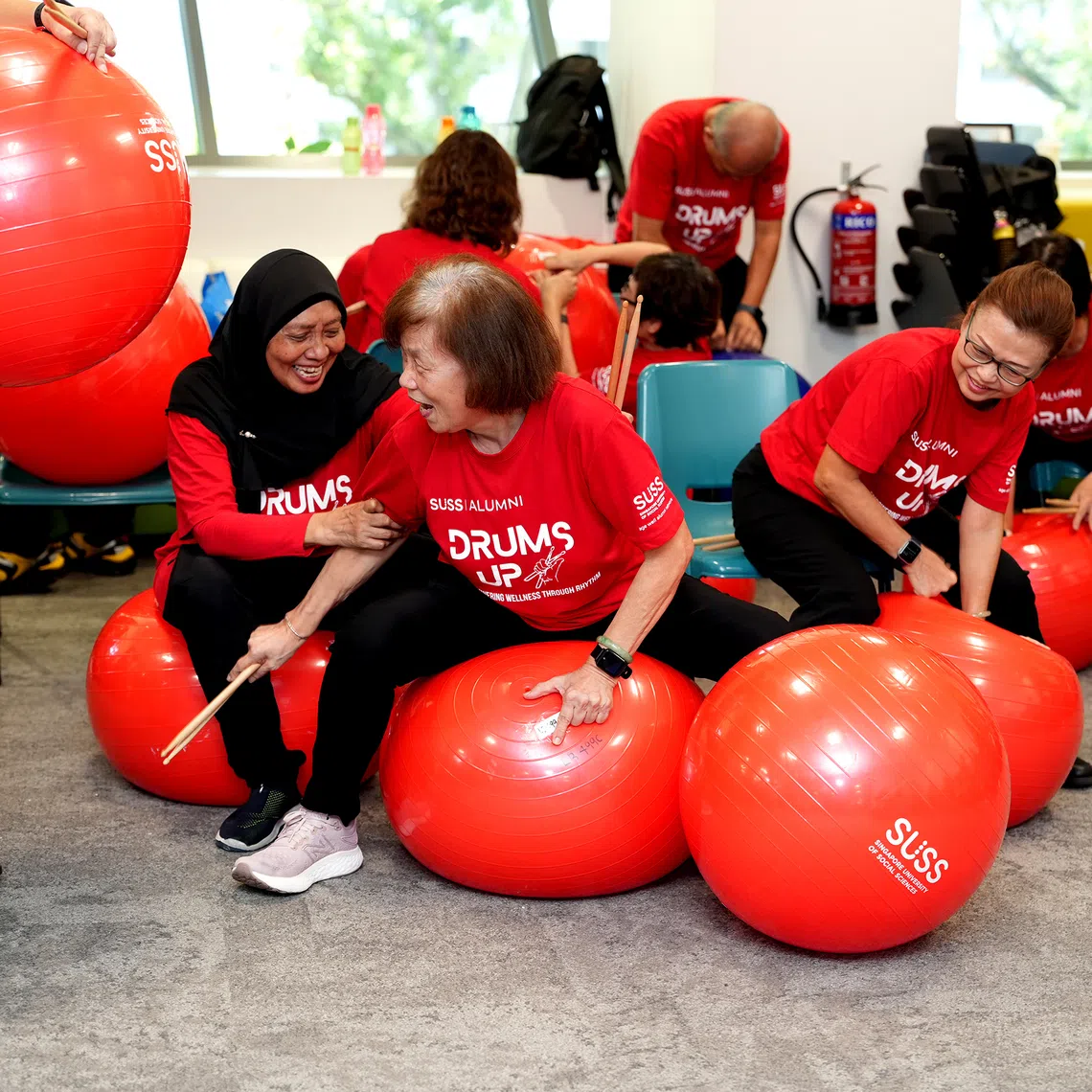 Seniors from different active ageing centres preparing for a cardio drumming performance at an SG60 NDP celebration event.