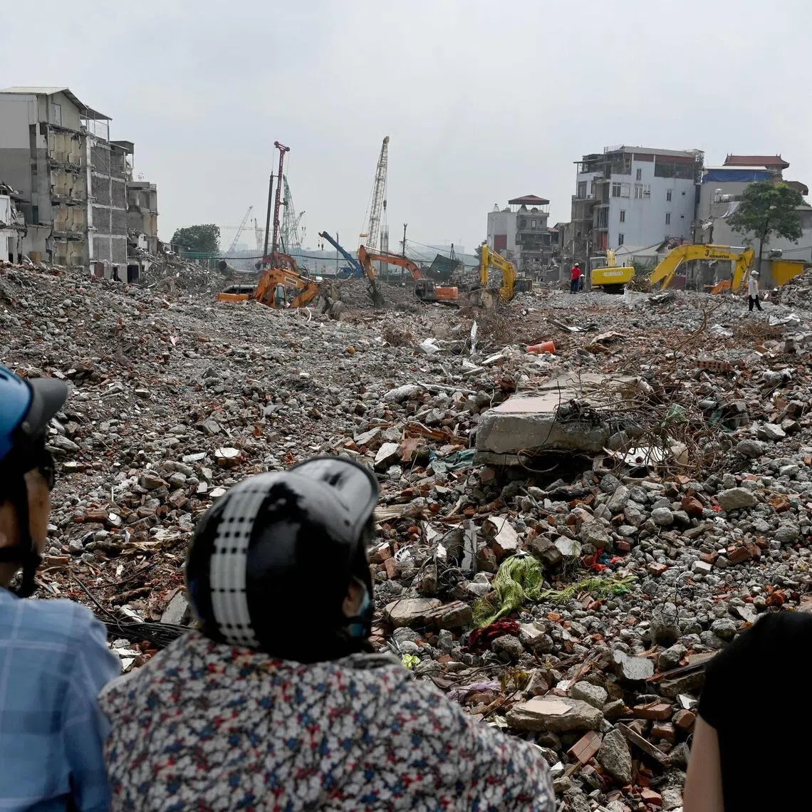 Onlookers view a field of rubble from residential buildings at a demolition site to make way for an expanded road network in Hanoi on May 18.