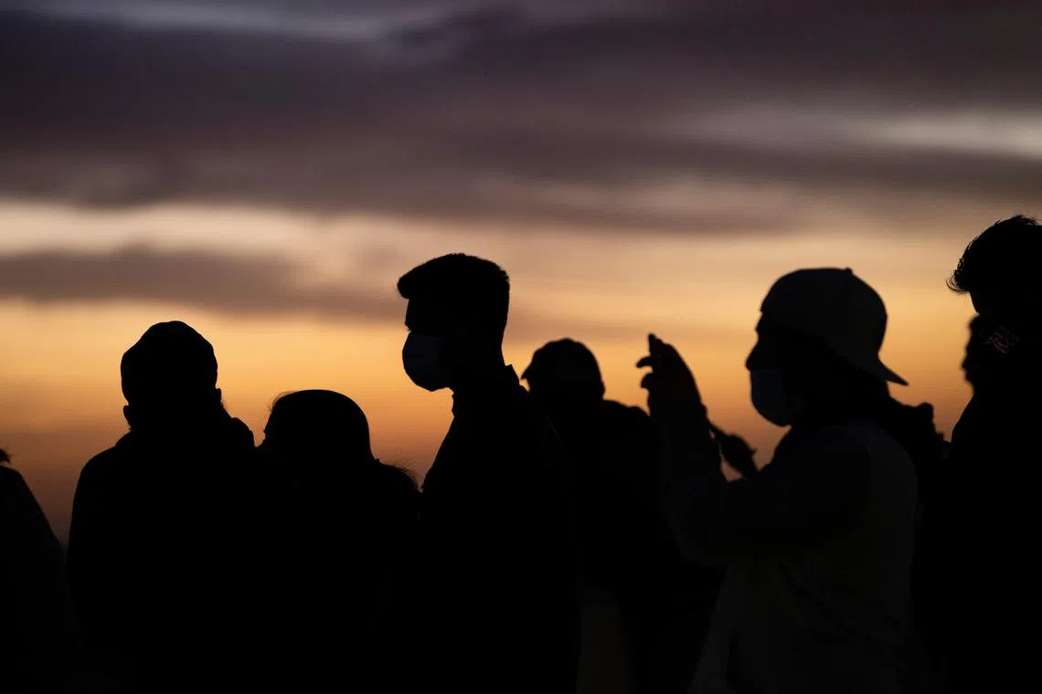 FILE PHOTO: People wearing face protective masks watch the sunset from Griffith Observatory during a partial lockdown during the outbreak of the coronavirus disease (COVID-19), in Los Angeles, California, U.S., December 7, 2020. REUTERS/Mario Anzuoni/File Photo