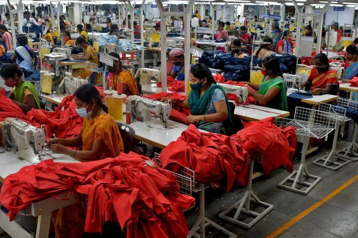 Garment workers stitch shirts at a textile factory in Hindupur town in Andhra Pradesh, India.
