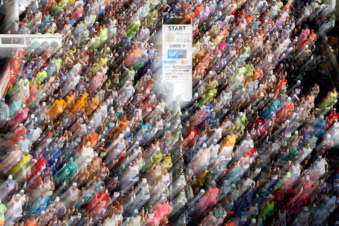 A slow shutter speed exposure showing runners setting off in front of the Tokyo Metropolitan Government building at the start of the Tokyo Marathon in the Shinjuku area of downtown Tokyo, Jaoan on March 1, 2026. 