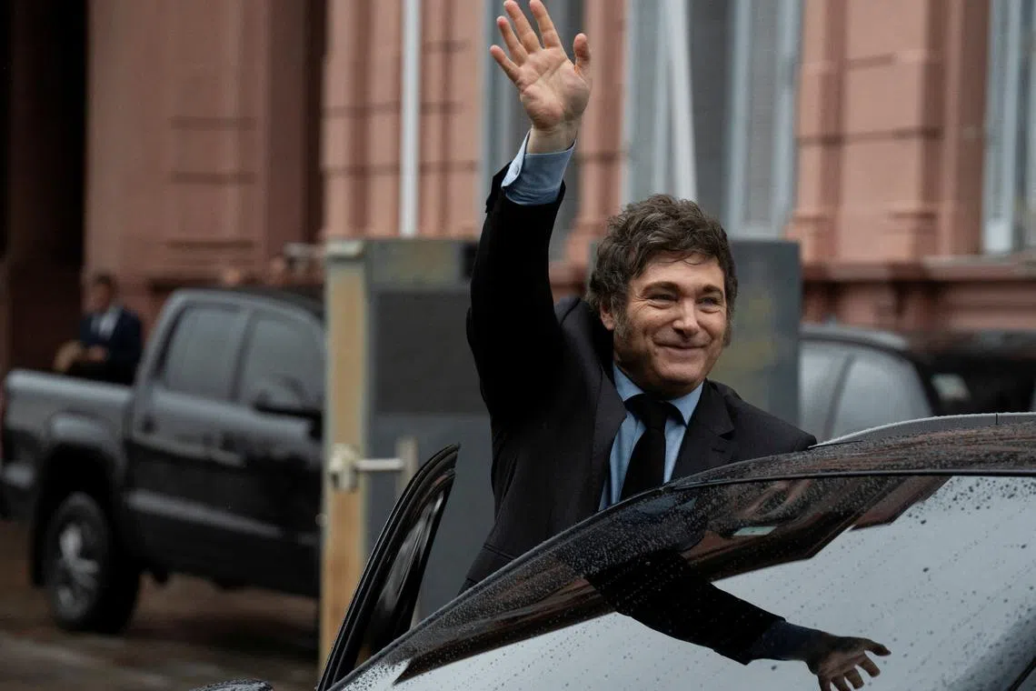 FILE PHOTO: Argentina's President Javier Milei greets from a car after a meeting with his French counterpart Emmanuel Macron at the Casa Rosada presidential palace, in Buenos Aires, Argentina November 17, 2024. REUTERS/Irina Dambrauskas/File Photo