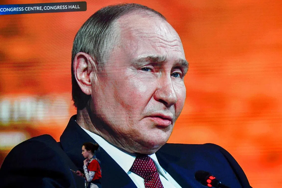 Russian President Vladimir Putin is seen on huge TV screens at the Saint Petersburg International Economic Forum.