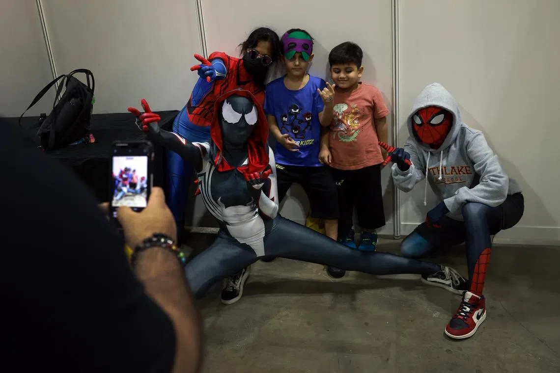 A group of Spider-Man cosplayers posing for a photograph with young fans during Singapore Comic Con at the Sands Expo & Convention Centre on Sunday (Dec 11, 2022). 