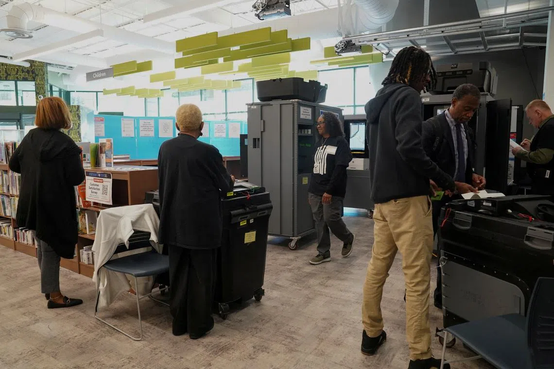 FILE PHOTO: People stand inside a polling station as Georgians turned out a day after the battleground state opened early voting, in Atlanta, Georgia, U.S., October 16, 2024. REUTERS/Megan Varner/File photo