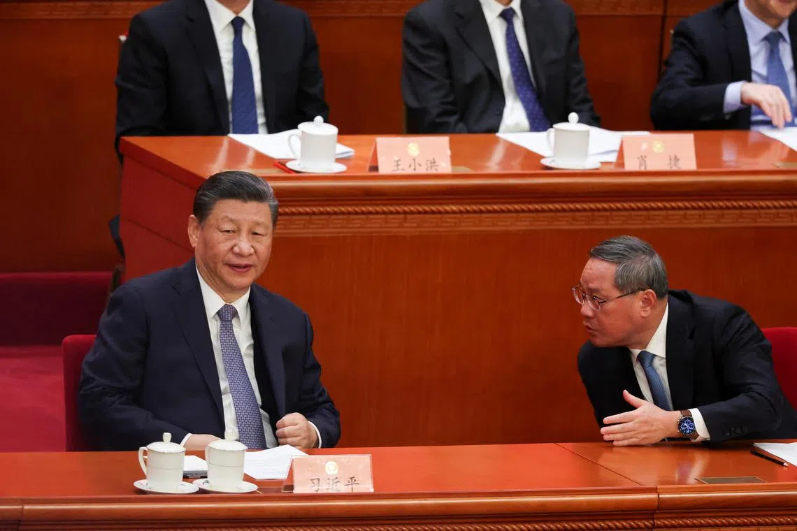 Chinese President Xi Jinping and Premier Li Qiang talk as they attend the opening session of the Chinese People's Political Consultative Conference (CPPCC) at the Great Hall of the People in Beijing, China March 4, 2024. REUTERS/Florence Lo
