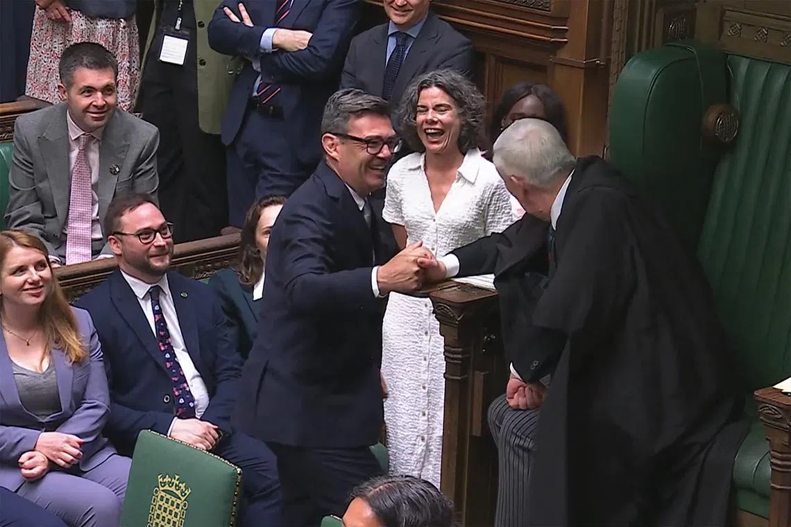 Newly sworn-in Labour MP for Makerfield Andy Burnham shaking hands with Britain's Speaker of the House of Commons Lindsay Hoyle in Parliament in London on June 22.