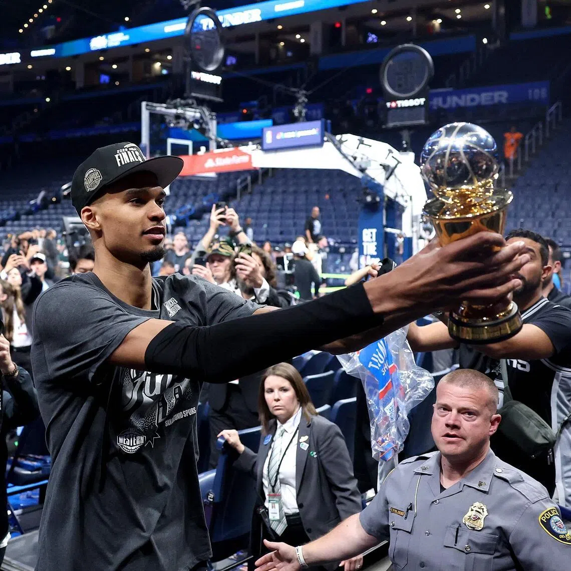 Victor Wembanyama of the San Antonio Spurs shows fans the Earvin "Magic" Johnson MVP Trophy after defeating the Oklahoma City Thunder in Game 7 of the NBA Western Conference Finals at Paycom Center.