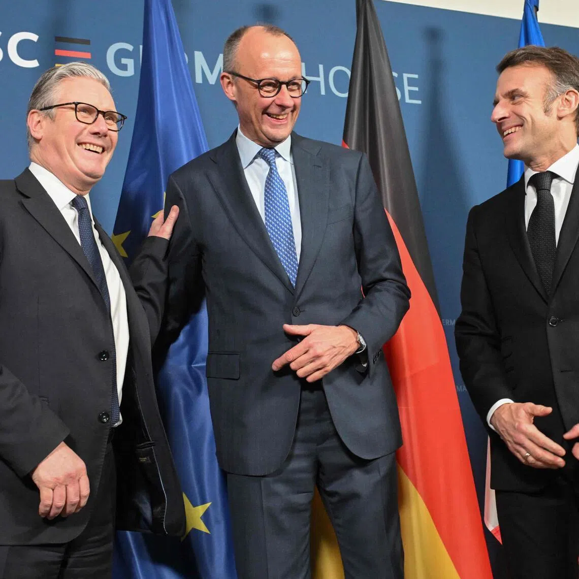 (L-R) British Prime Minister Keir Starmer, German Chancellor Friedrich Merz and France’s President Emmanuel Macron pose at the start of the E-3 meeting, during the Munich Security Conference, on February 13, 2026 in Munich. Heads of state and government as well as foreign and defence ministers from all over the world are expected to attend the security policy talks from February 13 to 15, 2026. (Photo by THOMAS KIENZLE / POOL / AFP)