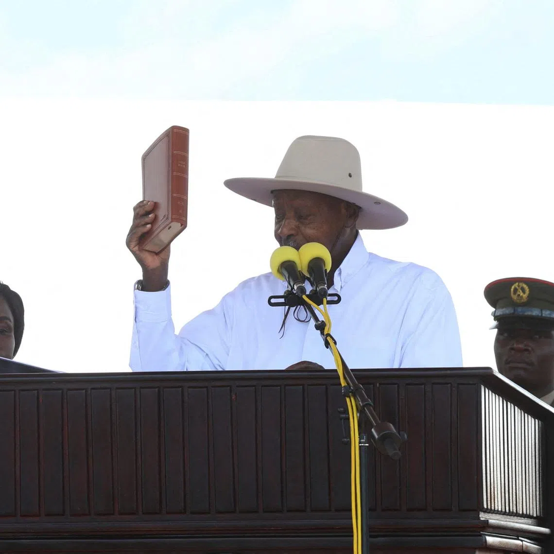 Uganda's President and the leader of ruling National Resistance Movement (NRM) party, Yoweri Museveni, holds up the Bible as he is sworn-in after being declared the winner of the country’s presidential election, extending his decades-long rule at the Kololo grounds in Kampala, Uganda May 12, 2026. REUTERS/Michael Muhati